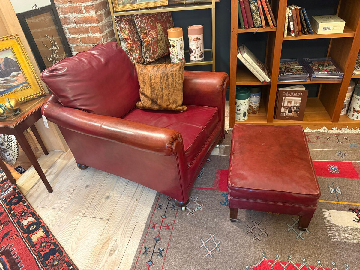 Oxblood leather wingback chair and ottoman, side view