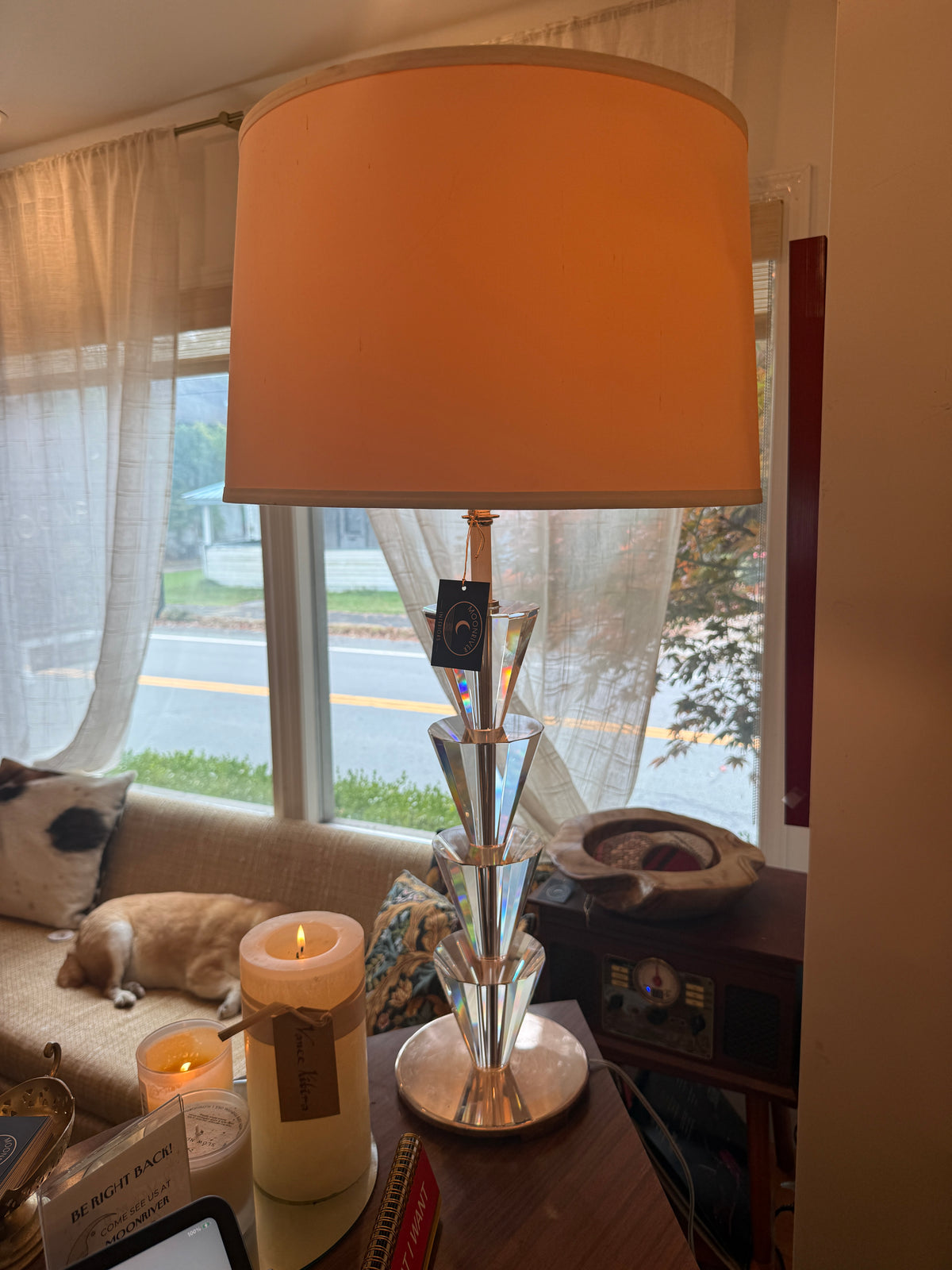 Stacked lucite and chrome table lamp, lit, by window